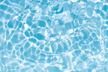 Blue water with ripples on the surface. Defocus blurred transparent blue colored clear calm water surface texture with splashes and bubbles. Water waves with shining pattern texture background.