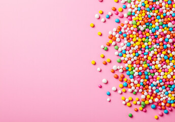 Colorful candy sprinkles on pink background create a vibrant, sweet, festive, and fun confectionery display.