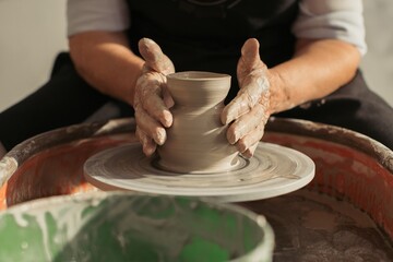 Potter creating clay vase on pottery wheel