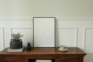 Minimalist home interior. Blank black picture frame mockup. Rustic wooden sideboard, dried flowers...