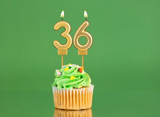Number 36 birthday candle - Cupcake on a green background