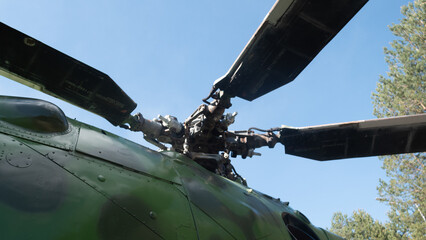 The helicopter rotor blades are showcased against a vibrant blue sky, emphasizing the engineering of Soviet aircraft. The image reflects a vintage aviation exhibit.