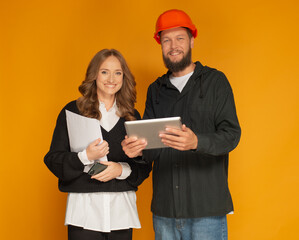 portrait of friendly confident professional architect and builder with documents and tablet in hands isolated.builder and architect designer working together looking at camera using tablet