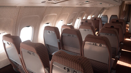 Fototapeta premium Empty passenger seats line the aisle of a Soviet-era airplane, featuring a vintage design that reflects the travel aesthetics of the USSR period.