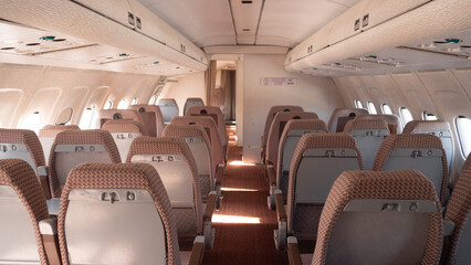 The cabin of a vintage Soviet aircraft boasts neatly arranged seats and soft lighting, showcasing...