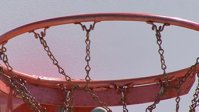 Orange Basketball Basket with a Ball that has Been Dunked Several Times