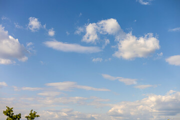 Beautiful afternoon sky with fluffy clouds and clear blue backdrop over a serene landscape