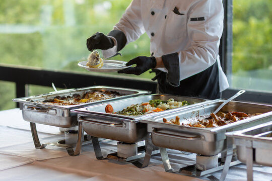 Catering staff serves food at a buffet in a modern venue during a corporate event