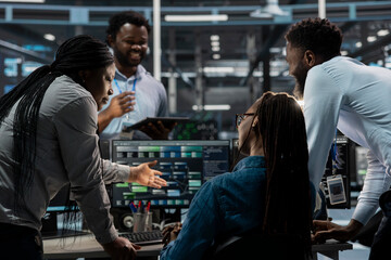 Coworkers programming in server farm housing advanced infrastructure storing massive datasets. Admins running code on PC to repair data center racks doing complex computational operations