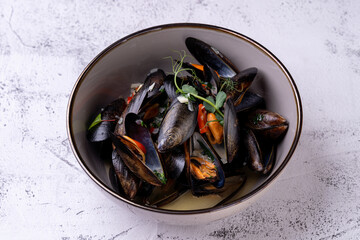 Savor the vibrant presentation of gourmet mussels elegantly displayed in a bowl, infused with fresh herbs and spices, showcasing a culinary masterpiece bursting with flavor