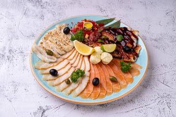A beautifully arranged platter features an assortment of gourmet seafood delicacies including smoked salmon, white fish, and garnishes like olives and lemon. This culinary delight invites exploration
