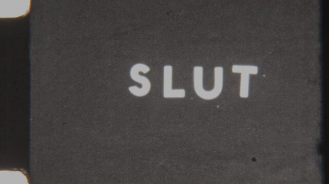 Analog 8mm Film Displaying The Word Slut In All Caps Fading To Black