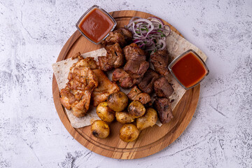 A mouthwatering assortment of grilled meats, succulent and perfectly cooked, paired with seasoned roasted potatoes. Accompanied by aromatic sauces and fresh onions, this feast teases the senses
