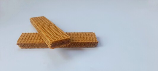 Two crispy and layered chocolate filled wafer biscuits stacked on a white background
