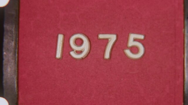 8mm Film Showing 1975 Year On Old Red Backdrop With Film Grain