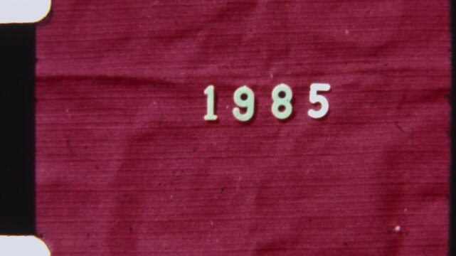 Distressed Red Film Frame With 1985 Year On Authentic 8mm Reel
