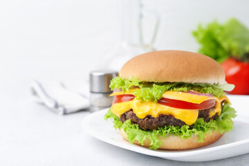 Tasty cheeseburger on white table, closeup. Space for text
