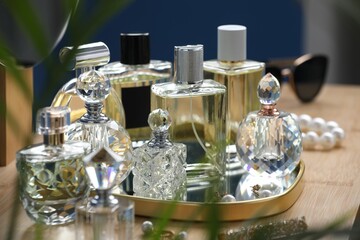Bottles of perfumes on wooden table indoors