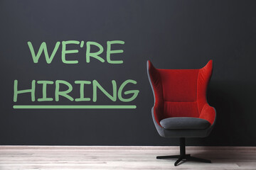 We Are Hiring. Empty office chair near dark wall. Recruitment, human resources concept