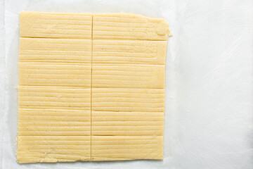 Top view of rolled out sugar cookie dough on a white countertop, process of making cut out sugar cookies