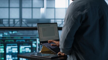 Engineer in data center operating notebook, deploying new server architectures. Server farm...