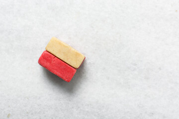 Overhead view of Vanilla and strawberry pink sugar cookie dough on a parchment lined baking sheet,...