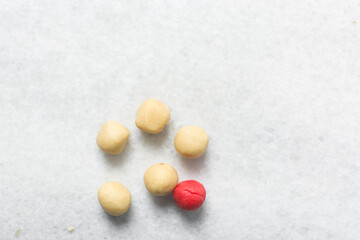 Overhead view of Vanilla and strawberry pink sugar cookie dough on a parchment lined baking sheet,...