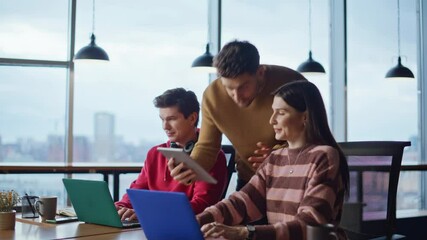 Team manager analyzing colleagues working at laptops in coworking space closeup.