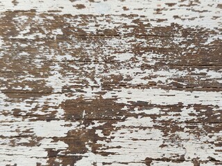 Detail of an old wooden surface, with peeling paint and visible cracks, bringing a sense of...