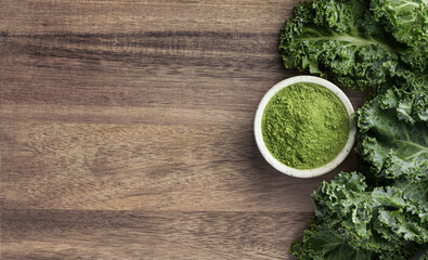  Kale Powder in ceramic bowl on a wooden background, top view, copy space