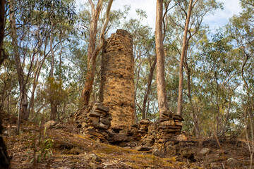 Old gold mining Chimney relic in Chewton near Castlemaine Victoria, Australia. In the bush land,...