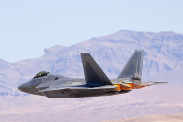 Extremely close  tail view of a  F-22 Raptor  against the Nevada hills, with afterburners on.