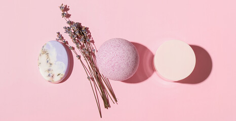 Composition with bath bomb, soap, jar of cosmetic product and lavender flowers on color background