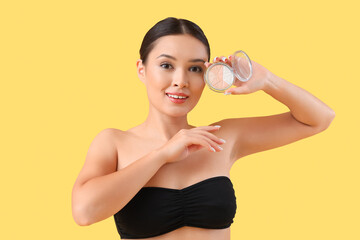 Young Asian woman with highlighter on yellow background, closeup