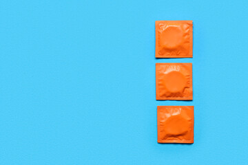 Set of wrapped condoms on color background