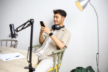 Smiling Broadcaster Using Smartphone, Have a Rest After Recording Session at Home Studio
