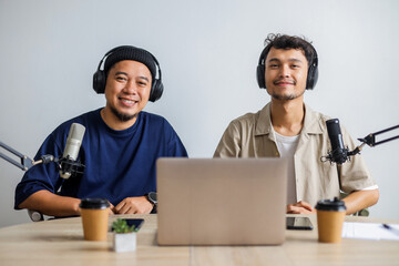 Portrait of Two Asian Men in Headphones Working on The Radio Station and Smiling to Camera