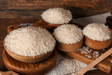 Bowls of rice on table against wooden background. Closeup