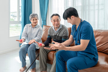 nurse or physiotherapist help senior family to exercise hands with squeeze ball at home,medical...