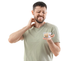 Young man with nuts itching on white background. Food Allergy Awareness Month