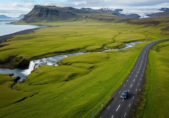 Open Road Landscape: A picturesque scene showcasing a road leading to a vast mountainscape, flanked by verdant fields and a flowing stream.