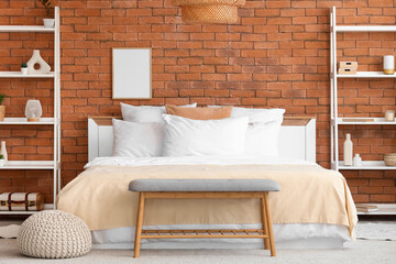 Interior of bedroom with cozy bed, bedside bench and shelving units