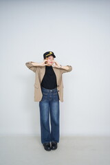 A collection of studio portraits featuring a stylish young woman posing in various confident stances against a clean white background.