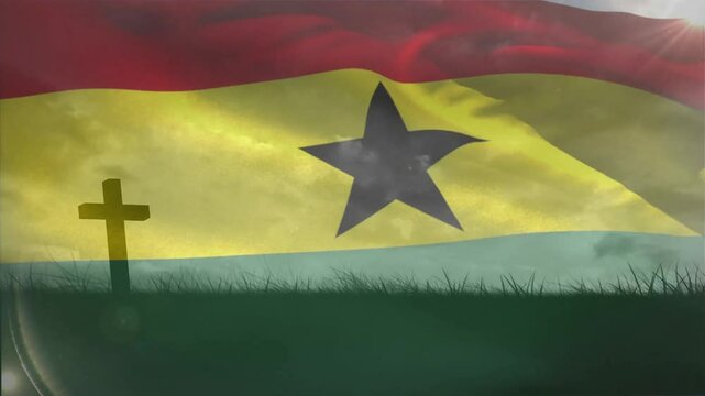 Wind blowing over memorial site causing Ghana flag rippling to honor memory while catching sunlight