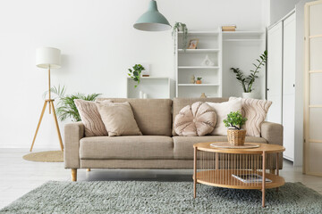 Interior of living room with soft couch, table and plants