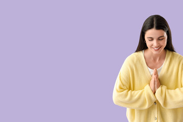 Thankful young woman on lilac background