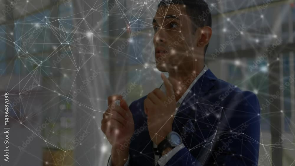 Poster man standing by office window shaping glowing network emerging around him linking data nodes