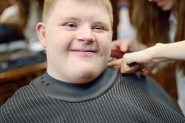 Portrait of a teenager with Down syndrome in a barbershop
