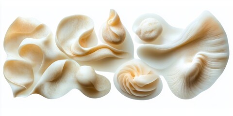 Close-up of several delicate, creamy white organic shapes with smooth curves and ruffled edges resembling mushroom caps or fungi arranged on a white background
