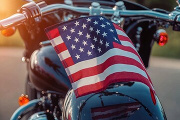 Close-up of an American flag attached to a shiny black motorcycle with sunlight glowing in the background